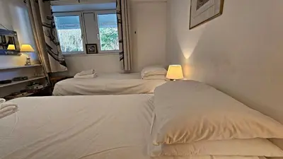 two white beds in a room with a window at Little Egret in Saint Mawes