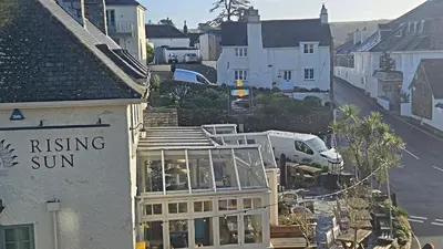 a building with a rising sun sign on the side of it at Little Egret in Saint Mawes