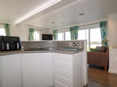 a kitchen with white cabinets and a microwave at South Crofty - The Residence in Redruth