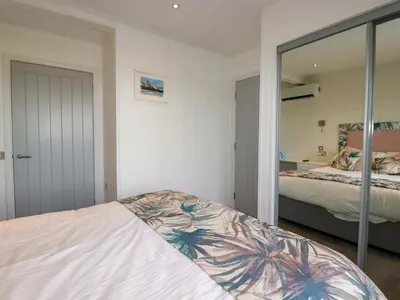 a bedroom with a bed and a mirror at South Crofty - The Residence in Redruth