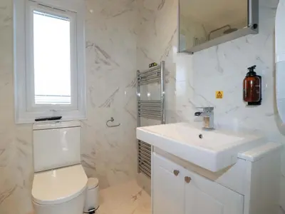 a white bathroom with a toilet and a sink at South Crofty - The Residence in Redruth