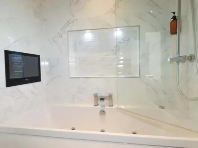 a white bathroom with a tub and a shower at South Crofty - The Residence in Redruth