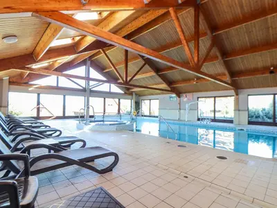 a swimming pool with a row of chairs in a building at South Crofty - The Residence in Redruth