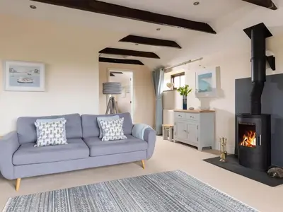 a living room with a blue couch and a fireplace at The Granary, Engollan in Wadebridge