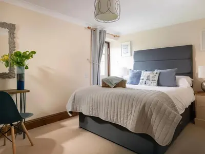 a bedroom with a large bed and a window at The Granary, Engollan in Wadebridge