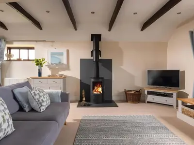a living room with a couch and a fireplace at The Granary, Engollan in Wadebridge