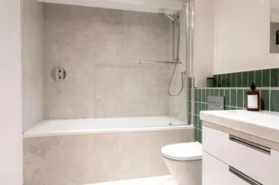 a bathroom with a shower and a tub and a toilet at Stunning sea-view apartment close to Fistral Beach in Crantock