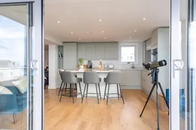a camera on a tripod in a kitchen with a table at Stunning sea-view apartment close to Fistral Beach in Crantock