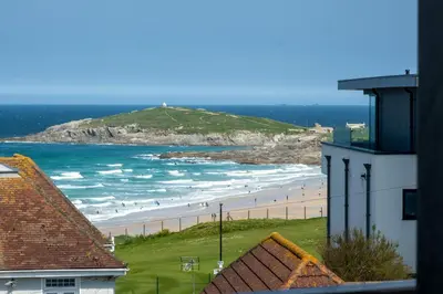 a view of a beach with people in the ocean at Stunning sea-view apartment close to Fistral Beach in Crantock