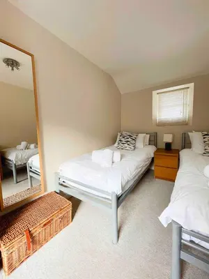 a bedroom with two beds and a large mirror at Seaside Cottage Ideal for Families and Surfers in St Ives
