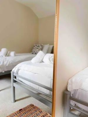 a mirror in a bedroom with two beds at Seaside Cottage Ideal for Families and Surfers in St Ives