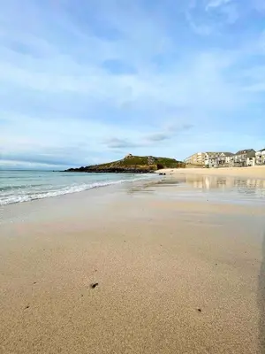 a sandy beach with houses and the ocean at Seaside Cottage Ideal for Families and Surfers in St Ives