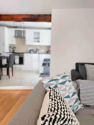a living room with a couch and a kitchen at Seaside Cottage Ideal for Families and Surfers in St Ives