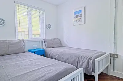 two twin beds in a room with a window at The Artist's Cottage in Uny Lelant