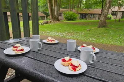 a picnic table with plates of food on it at The Artist's Cottage in Uny Lelant