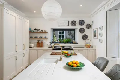 a kitchen with a sink and a bowl of fruit on a counter at Beautiful Perranporth country house near the beach in Perranzabuloe