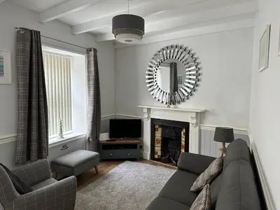 a living room with a couch and a mirror at Kerris Cottage in St Ives