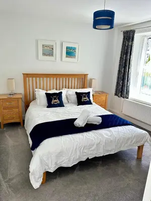 a bedroom with a large bed with towels on it at Kerris Cottage in St Ives