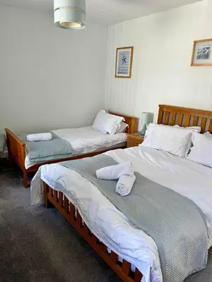 a room with two beds with towels on them at Kerris Cottage in St Ives