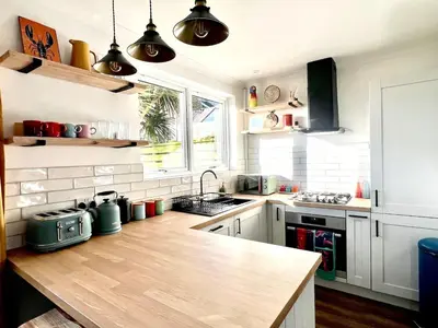 a kitchen with a wooden counter top in a room at 3-Bedroom Holiday Home, Newquay with Garden & Parking - 150 Steps to the Beach! in Newquay