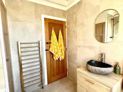a bathroom with a sink and a wooden door at 3-Bedroom Holiday Home, Newquay with Garden & Parking - 150 Steps to the Beach! in Newquay