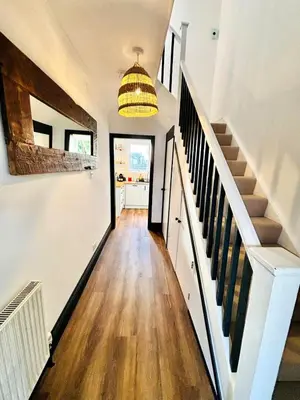 a hallway of a home with white walls and wooden floors at 3-Bedroom Holiday Home, Newquay with Garden & Parking - 150 Steps to the Beach! in Newquay