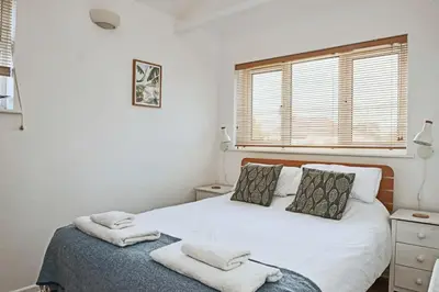 a bedroom with a white bed with towels on it at Finest Retreats - Templemore in Widemouth Bay