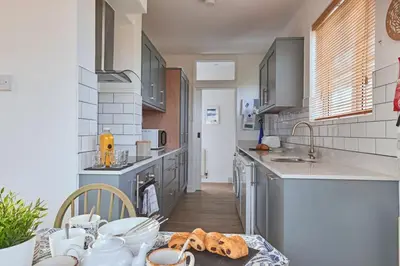 a kitchen with a table with bread on it at Finest Retreats - Templemore in Widemouth Bay