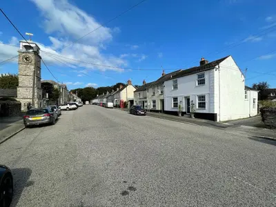 an empty street in a small town with a clock tower at Trewenna in Tregoney