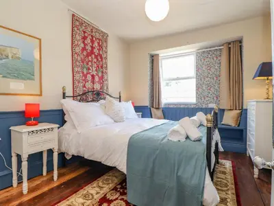 a bedroom with a bed with a teddy bear on it at Trewenna in Tregoney