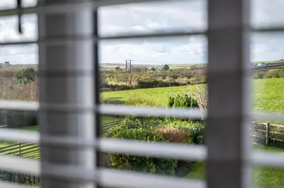 a view of a field from a window at Treallen Rock in Saint Minver