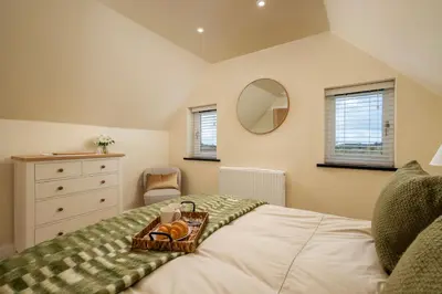 a bedroom with a bed with a tray of food on it at Treallen Rock in Saint Minver