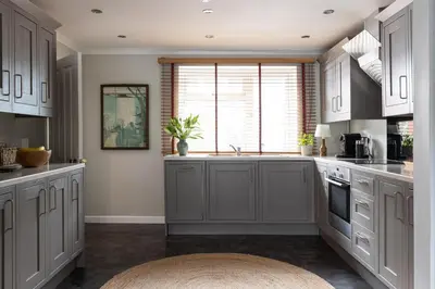 a kitchen with gray cabinets and a sink at Easy Oars - Flushing, Falmouth in Flushing