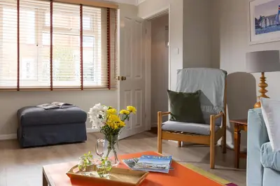 a living room with a coffee table and a chair at Easy Oars - Flushing, Falmouth in Flushing