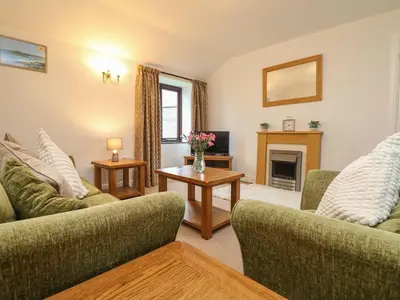 a living room with two couches and a fireplace at Little Tregarrick in Helston
