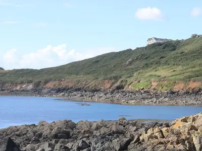 a large body of water with a rocky beach at Little Tregarrick in Helston