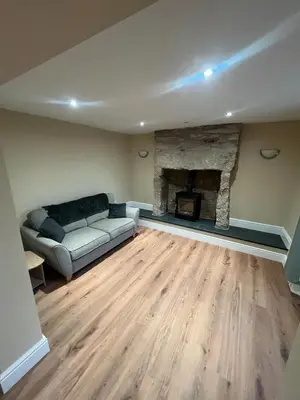 a living room with a couch and a fireplace at Cosy Cottage Hot Tub Sleeps 8 Log Fires in Carnbrea