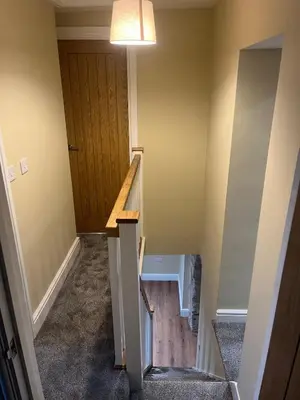 a staircase in a house with a wooden door at Cosy Cottage Hot Tub Sleeps 8 Log Fires in Carnbrea