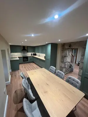 a conference room with a wooden table and chairs at Cosy Cottage Hot Tub Sleeps 8 Log Fires in Carnbrea