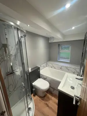 a bathroom with a tub and a toilet and a sink at Cosy Cottage Hot Tub Sleeps 8 Log Fires in Carnbrea