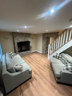 a living room with two couches and a fireplace at Cosy Cottage Hot Tub Sleeps 8 Log Fires in Carnbrea