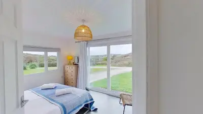 a bedroom with a bed and a large window at D05 Cedrica, Riviere Towans in Hayle