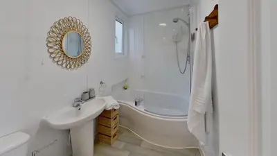 a white bathroom with a tub and a sink and a shower at D05 Cedrica, Riviere Towans in Hayle