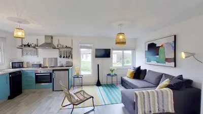 a living room with a couch and a kitchen at D05 Cedrica, Riviere Towans in Hayle