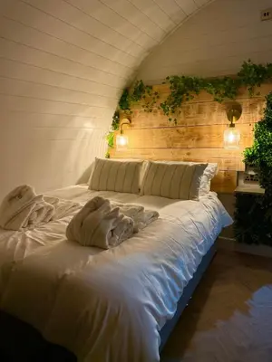 a large white bed with two pillows on it at The Secret Garden Glamping Cornwall in Cury