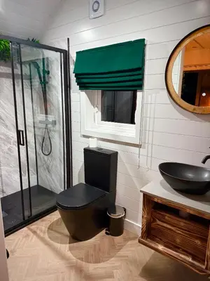 a bathroom with a toilet and a sink and a shower at The Secret Garden Glamping Cornwall in Cury