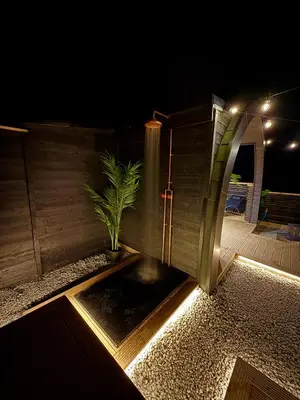 a water fountain in a backyard at night at The Secret Garden Glamping Cornwall in Cury