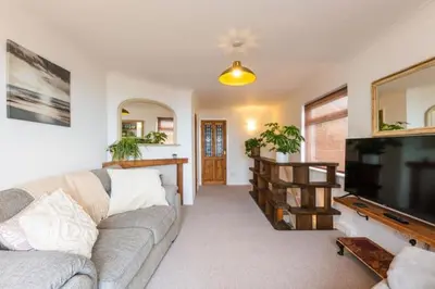 a living room with a couch and a flat screen tv at Looe sea view sleeps 2 free parking in Looe
