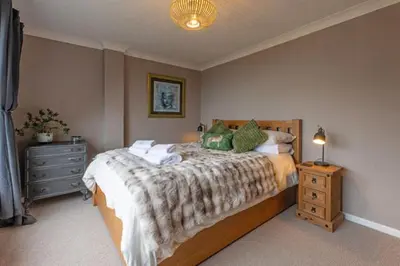 a bedroom with a bed and a dresser and a lamp at Looe sea view sleeps 2 free parking in Looe