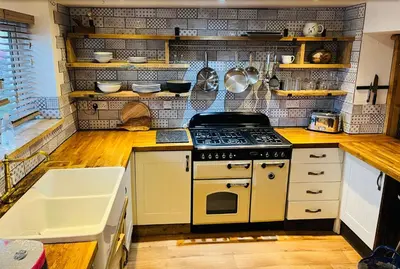 a kitchen with a stove top oven next to a sink at Looe sea view sleeps 2 free parking in Looe